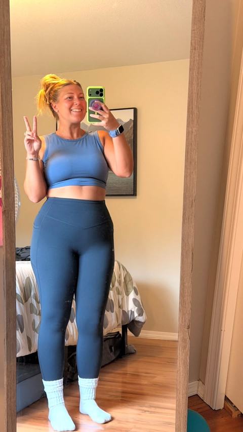 Debrah smiling and making a peace sign in a full-length photo
